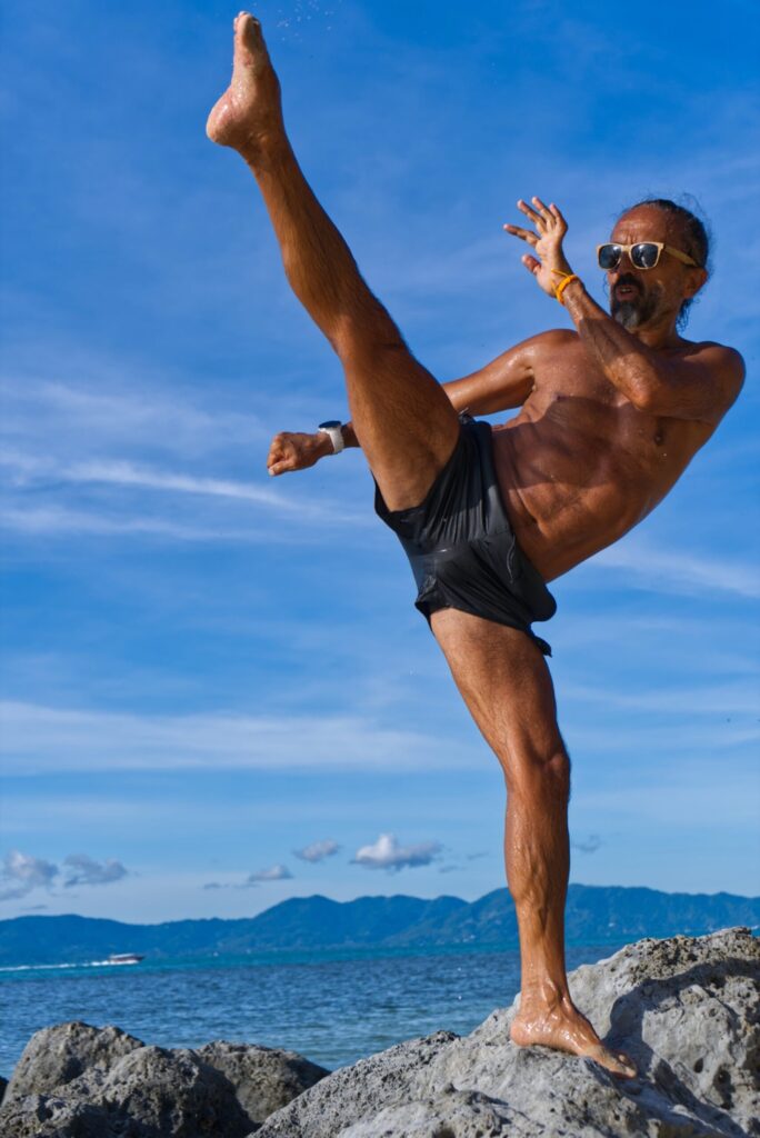 Trainer Nader Hashem bei einem hohen Kick auf einem Felsen am Meer